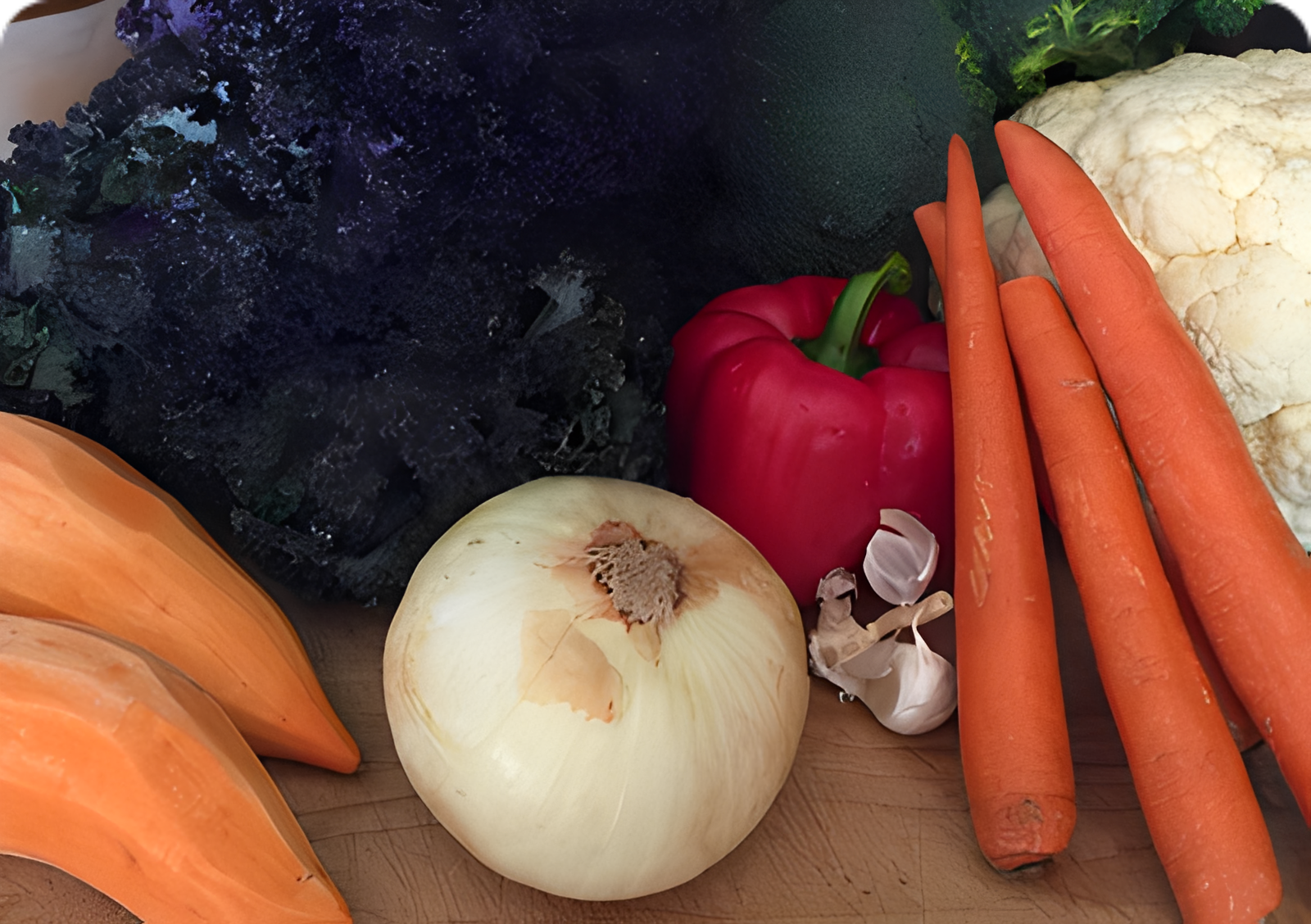 Assorted fresh vegetables on a wooden surface.